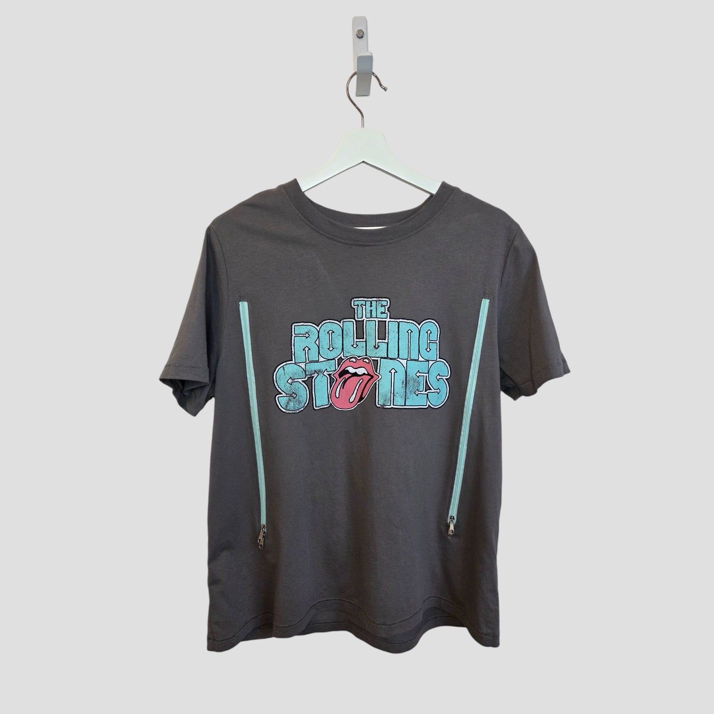 The Rolling Stones Upcycled Breastfeeding & Pumping T-shirt in grey/turquoise (L) features the band's logo and side zippers for nursing—ideal upcycled wear for music-loving moms.