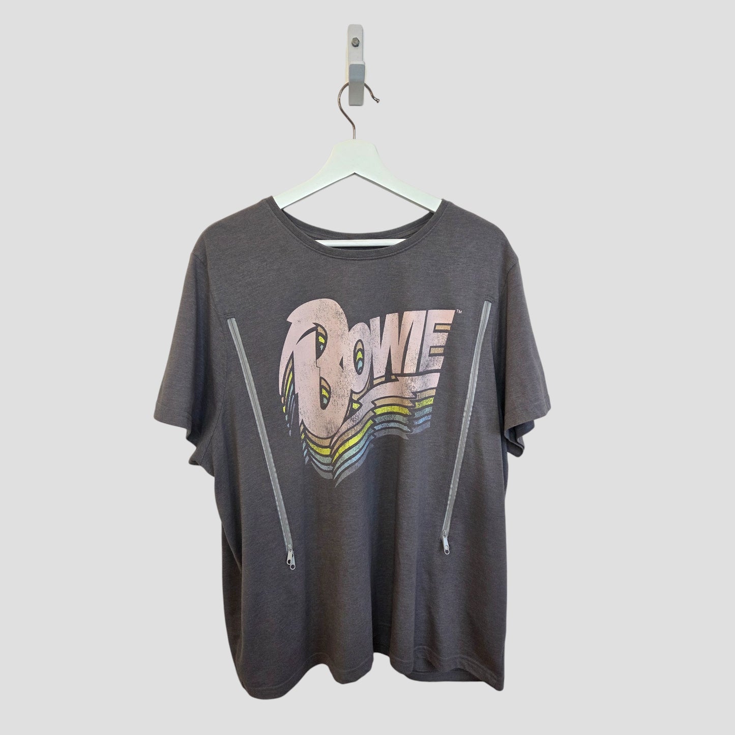 The Tu Upcycled Breastfeeding & Pumping Grey/Pastel Bowie Band t-shirt (UK22) features retro-style "Bowie" lettering with a rainbow underline and two zip details—an affordable, standout plus-size top perfect for nursing moms.