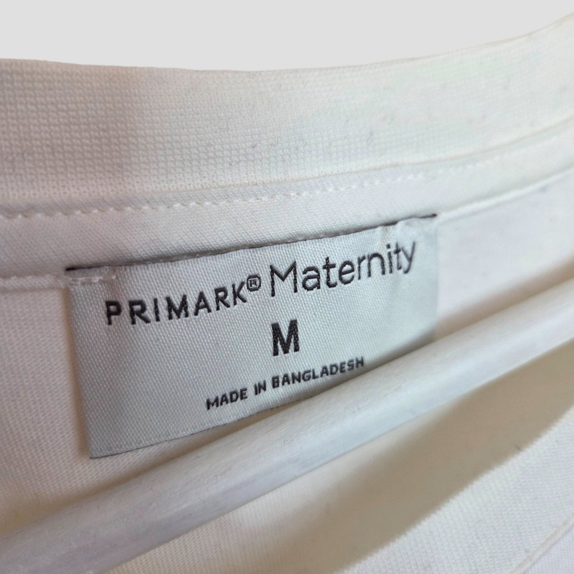 A white label on this Primark Upcycled Breastfeeding (Nursing) & Pumping White/Black MAMA t-shirt M (100373) reads PRIMARK® Maternity M MADE IN BANGLADESH, sewn into the inside collar for comfort and style.
