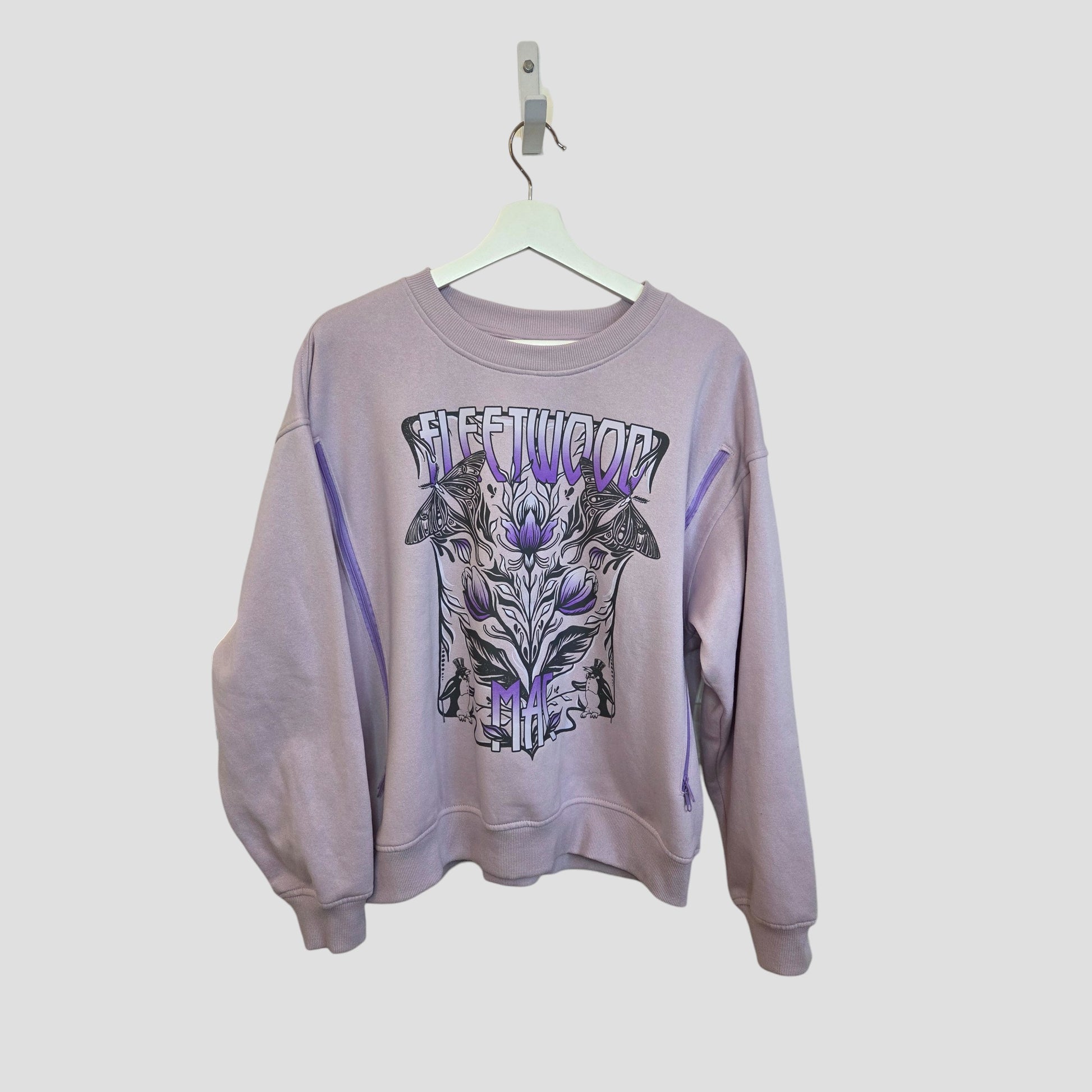 This upcycled H&M lilac sweatshirt (size M) for breastfeeding and pumping features a bold abstract floral and butterfly Fleetwood Mac graphic—an eco-friendly twist on classic band merch.