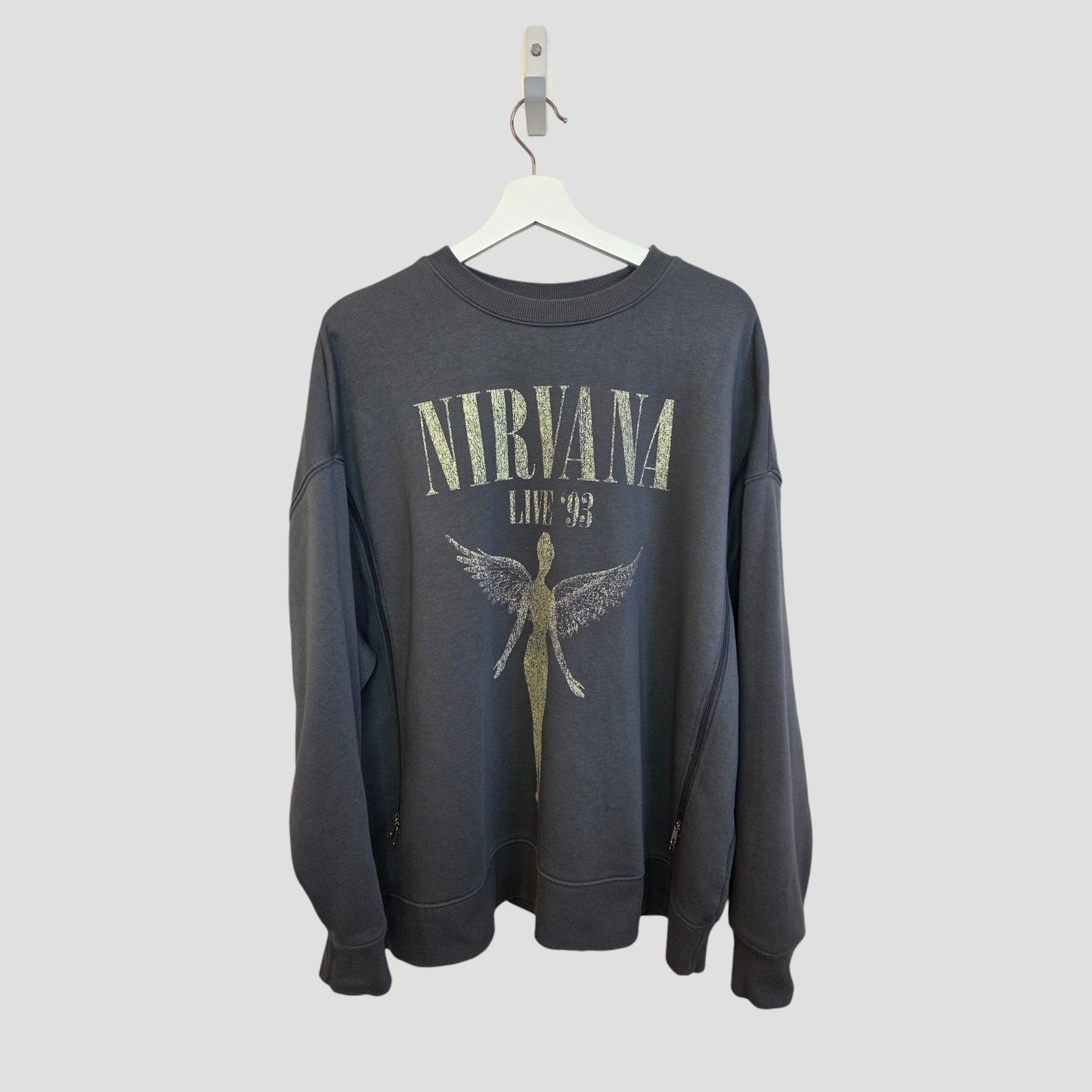 The Primark Upcycled Breastfeeding & Pumping Grey Nirvana Angel Band Sweatshirt XL (100419) features “NIRVANA LIVE ‘93” text and an angel graphic, crafted from upcycled nursing wear and shown on a white hanger with a light gray background.