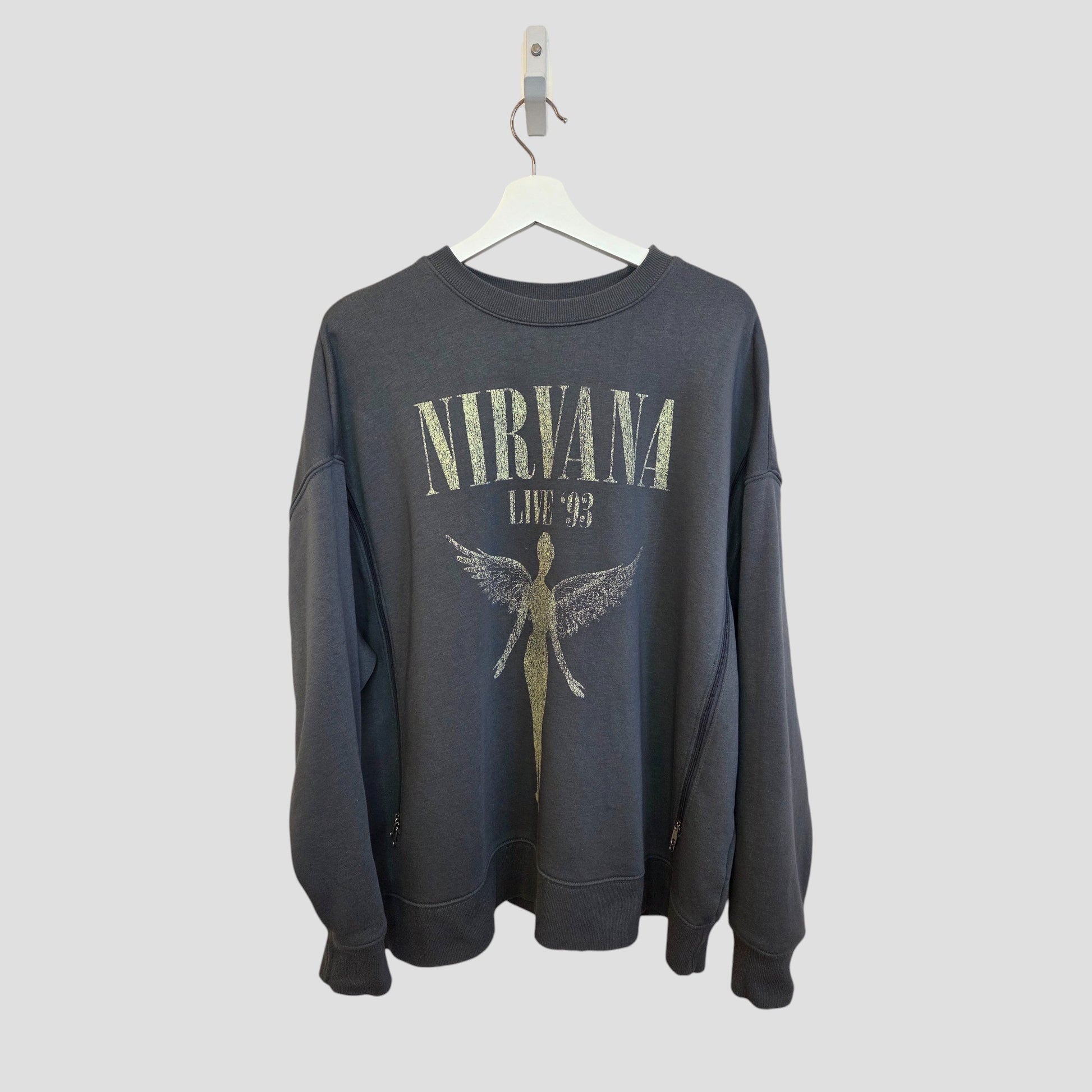The Primark Upcycled Breastfeeding & Pumping Grey Nirvana Angel Band Sweatshirt XL (100419) features “NIRVANA LIVE ‘93” text and an angel graphic, crafted from upcycled nursing wear and shown on a white hanger with a light gray background.