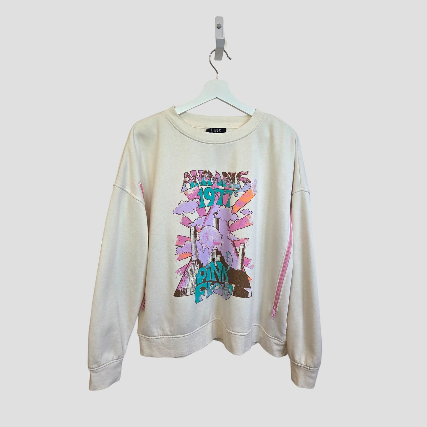 The Primark Upcycled Breastfeeding & Pumping Cream Pink Floyd Band Sweatshirt (L, 100414) features a vibrant Animals 1977 graphic and is made from upcycled materials, shown on a white hanger against a plain background.