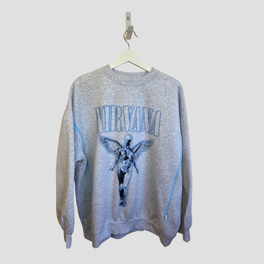 An H&M upcycled breastfeeding & pumping Nirvana band sweatshirt in light grey/blue, size L, featuring bold NIRVANA text above a winged angel image—an eco-friendly choice reimagined from nursing wear.
