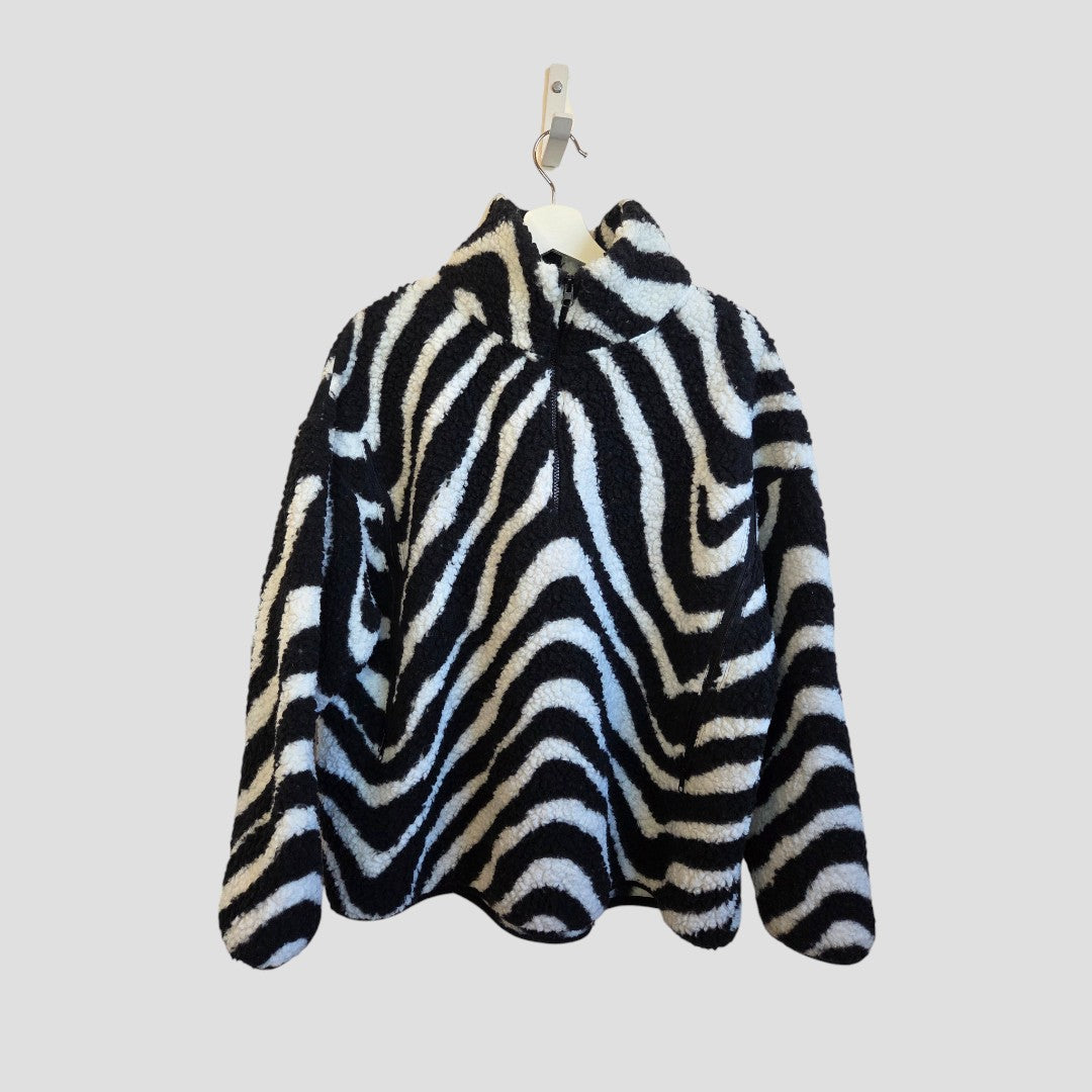 The Primark Upcycled Breastfeeding & Pumping Zebra Zip Oversized Fleece (M, 100478), in a black and white zebra print, is shown on a white hanger against a plain light gray background.