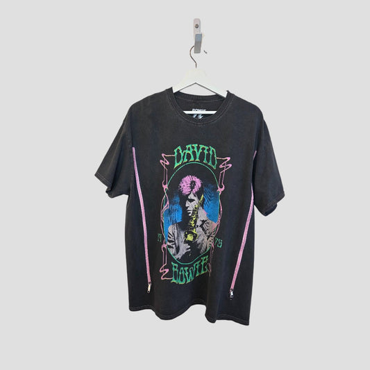 The Upcycled Breastfeeding & Pumping David Bowie Saxophone Band t-shirt (M/L, 100458) by David Bowie features a colorful saxophone graphic and green logo, made as an eco-friendly alternative. Shirt shown on white hanger against a plain background.