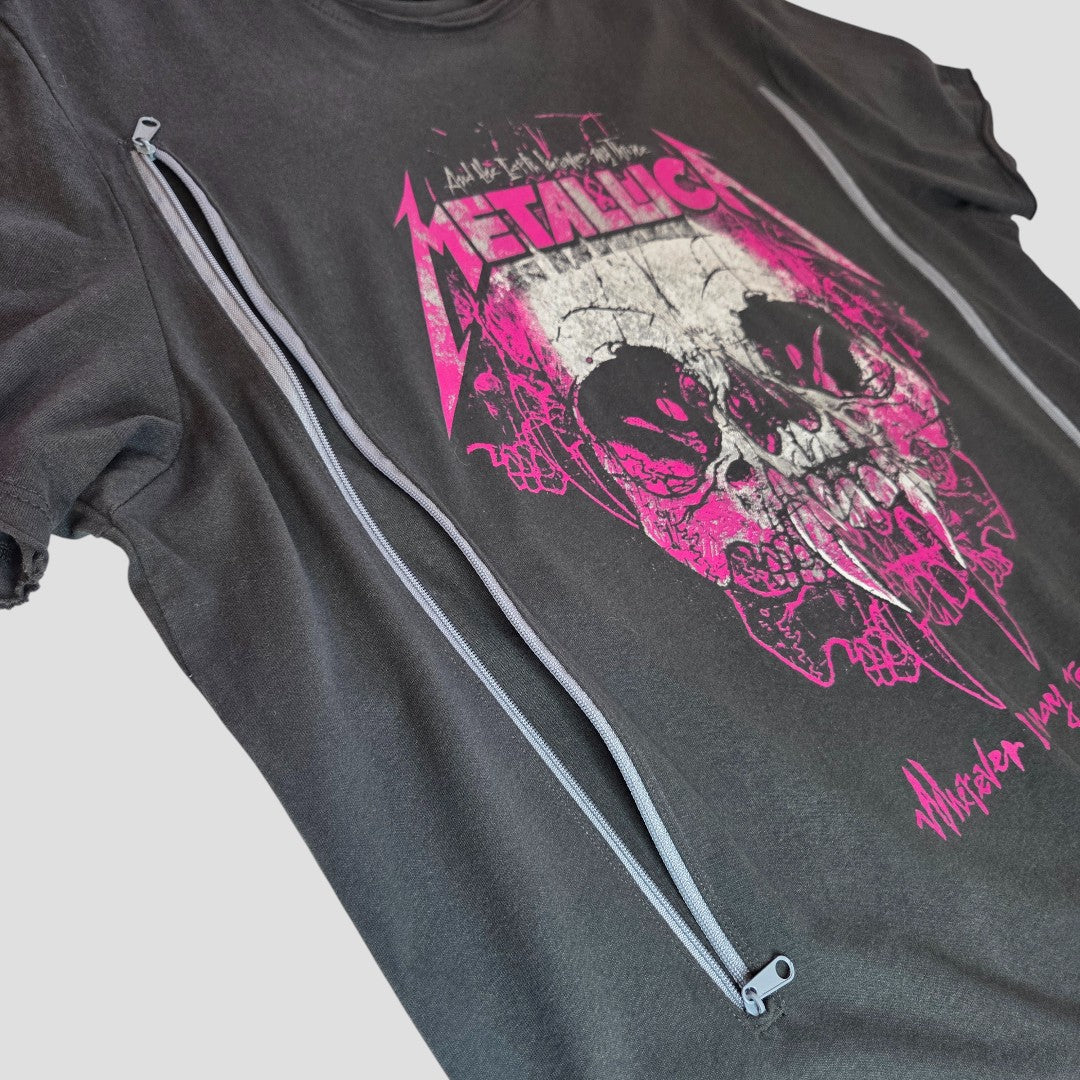The Amplified Upcycled Breastfeeding & Pumping Grey/Bright Pink Metallica Band T-shirt (XXL) features a distressed pink logo and skull, with two side zippers for easy nursing. Eco-friendly, stylish, and set against a plain light gray background.