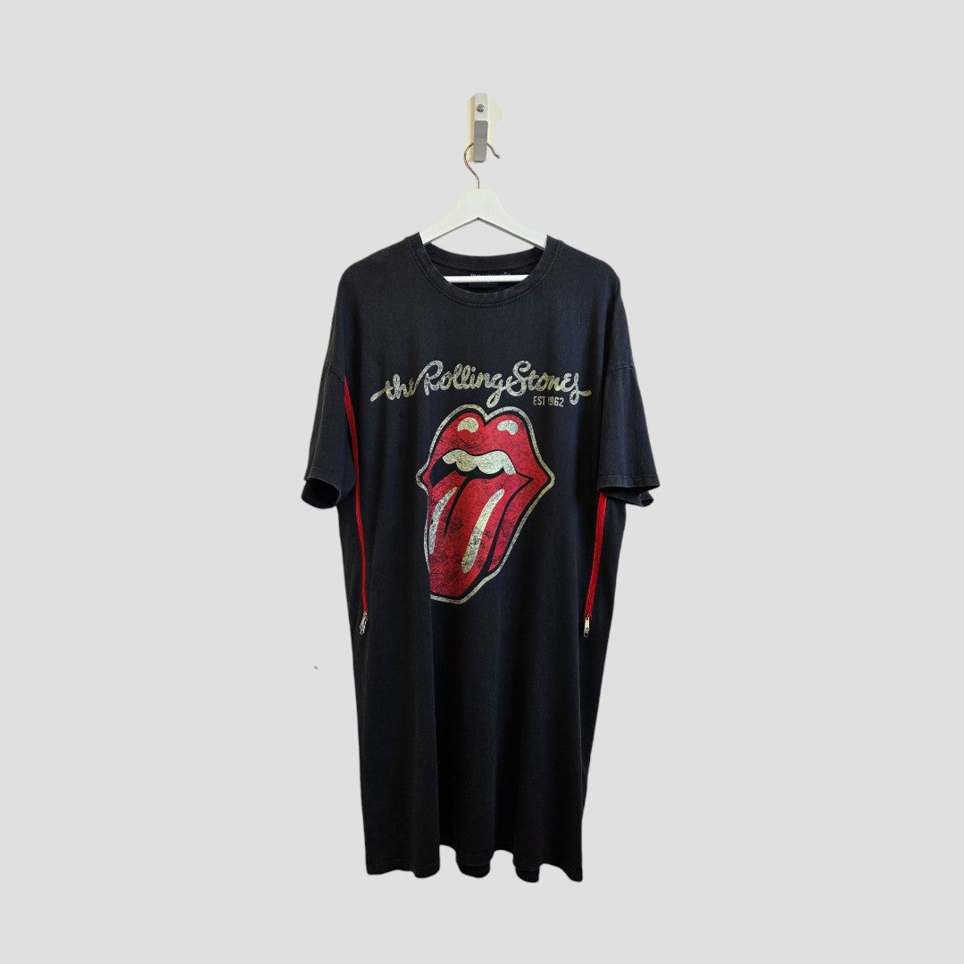 An upcycled Primark black Rolling Stones band T-shirt dress (UK12/14), ideal for breastfeeding and pumping, hangs on a white hanger against a plain light gray background, featuring the iconic red tongue and lips logo.