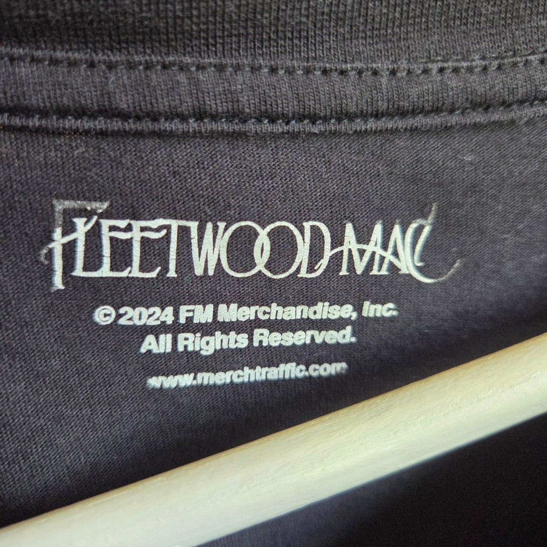 Close-up of an upcycled Fleetwood Mac nursing & pumping t-shirt’s inner collar in black, showing the 2024 FM Merchandise, Inc. logo and www.merchtraffic.com in white—sustainable apparel designed for breastfeeding moms.
