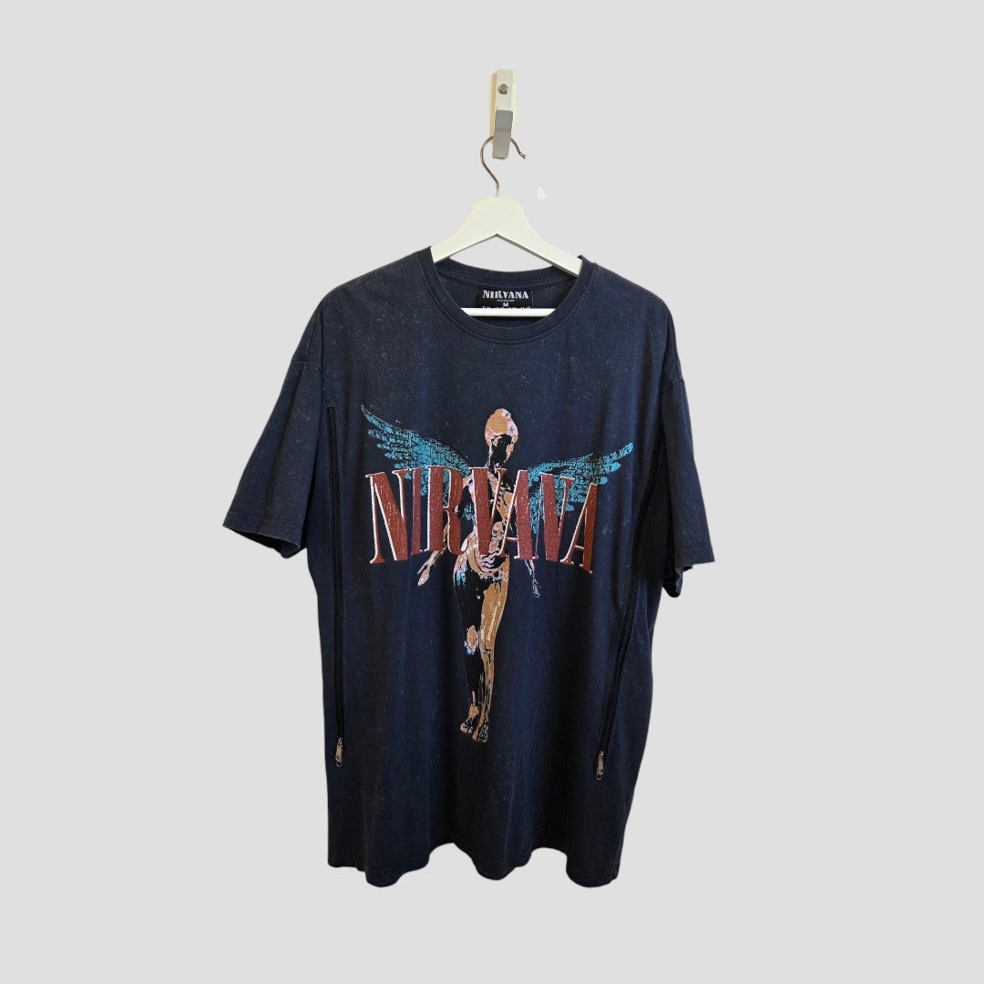 A Primark Upcycled Breastfeeding & Pumping Nirvana Band t-shirt in grey/turquoise (M UK12/14) hangs on a white hanger against a light gray background, featuring the band's name and a winged anatomical figure. Stylish nursing wear for fans.