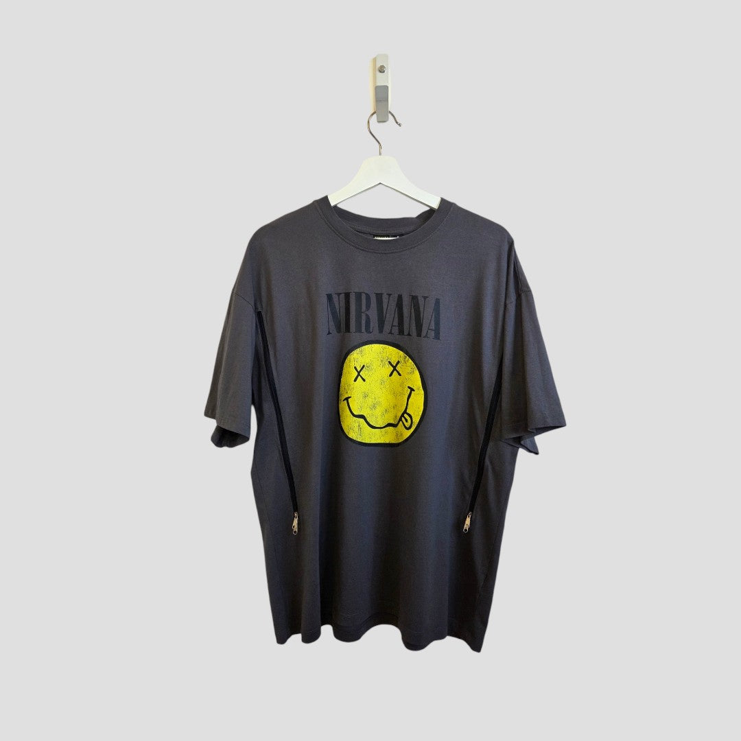 Primark Upcycled Breastfeeding & Pumping Nirvana Yellow Smile Band t-shirt (M, UK12/14) hangs on a plain light gray background, featuring the band's name in bold above a yellow smiley face. Made from eco-friendly materials.