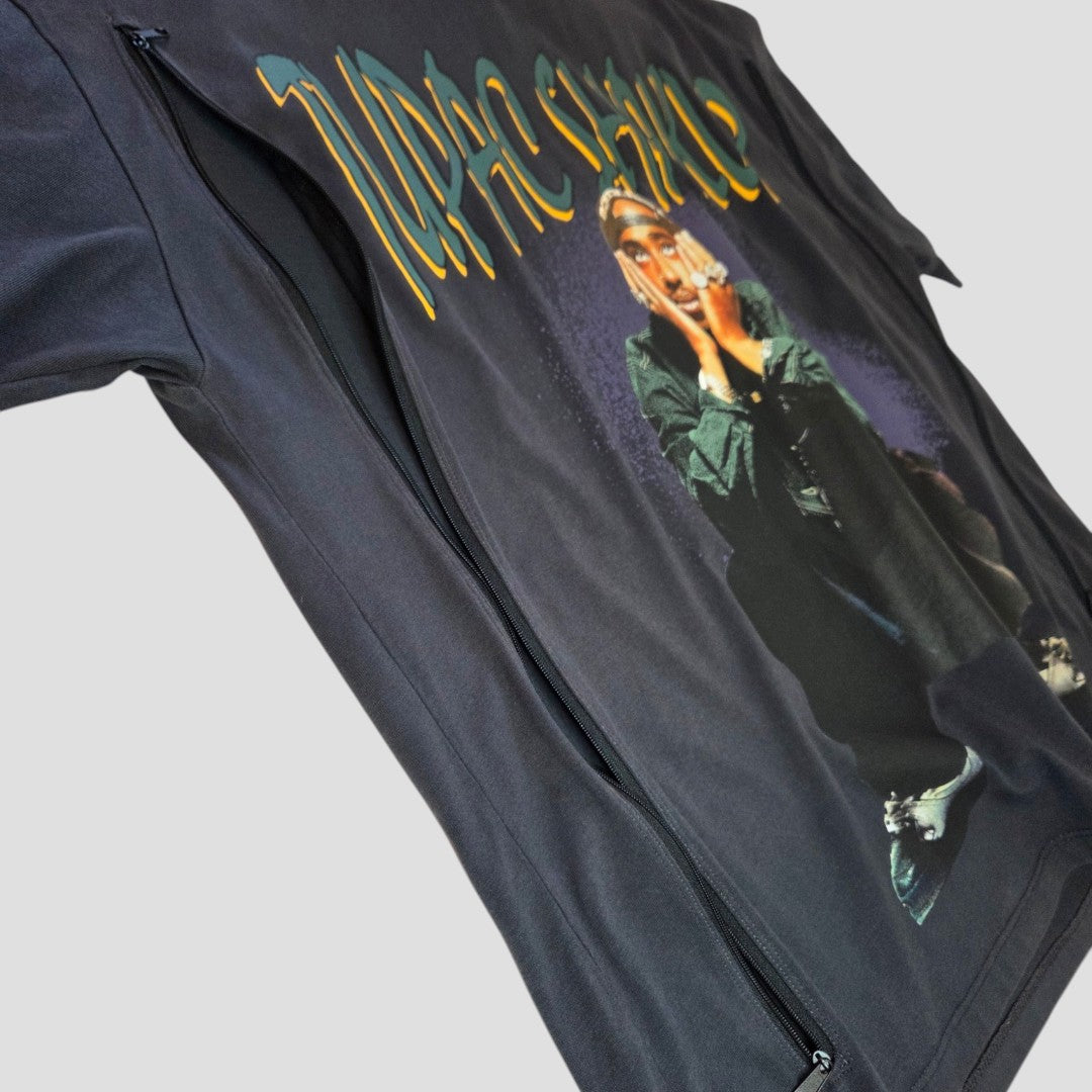 A grey Primark Upcycled Breastfeeding & Pumping Tupac Band t-shirt (UK14/16) is laid flat with two vertical zippers and features a large graphic of a seated person covering their mouth, topped with yellow stylized text.