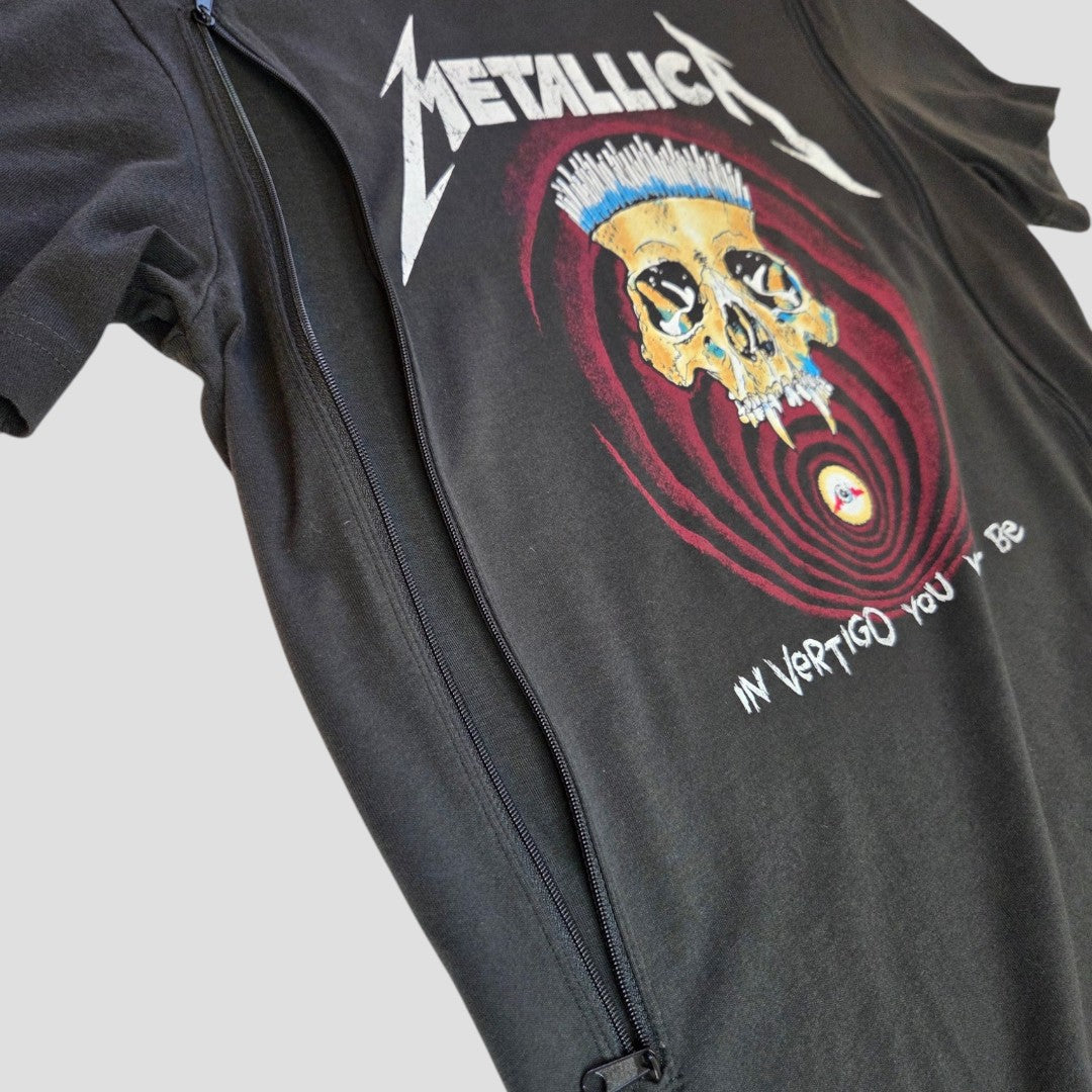 The H&M Upcycled Breastfeeding Black Metallica Skull Band t-shirt XS (100107) features a yellow skull with blue hair graphic, red concentric circles, IN YOPRIGO YOU N BE text, and a visible diagonal zipper for stylish and affordable nursing wear.