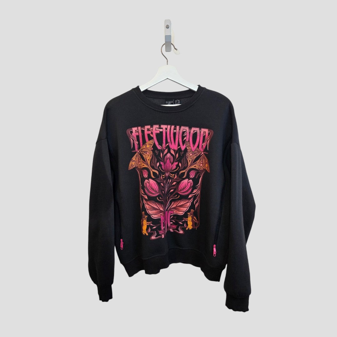 A black Primark upcycled breastfeeding sweatshirt (UK10/12) hangs on a white hanger, featuring a bold, colorful Fleetwood Mac floral graphic—an eye-catching addition to any nursing or pumping wardrobe.