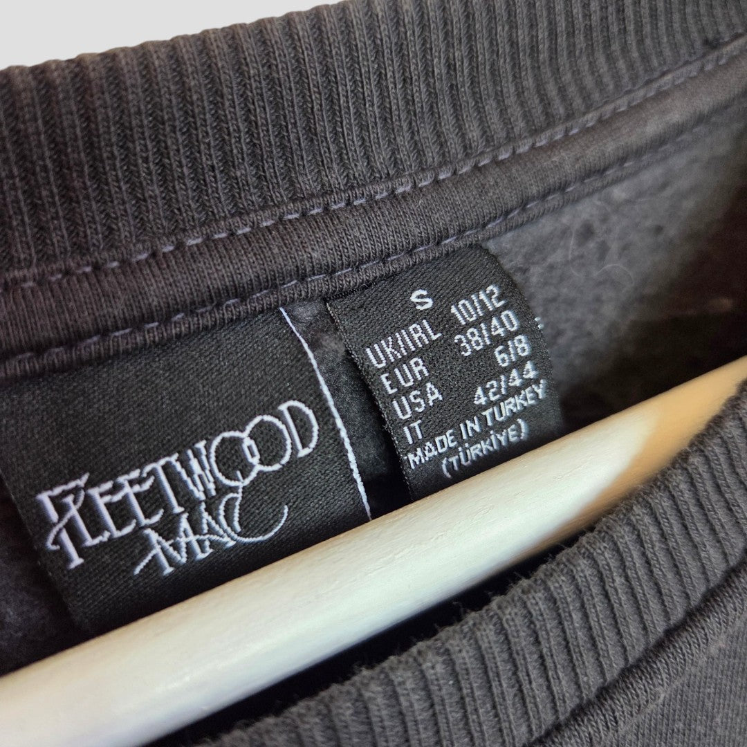 Close-up of a Primark upcycled breastfeeding & pumping floral Fleetwood Mac band sweatshirt tag (size S UK10/12), showing the logo, regional sizing, and "Made in Turkey." Perfect for fans wanting unique nursing wear.