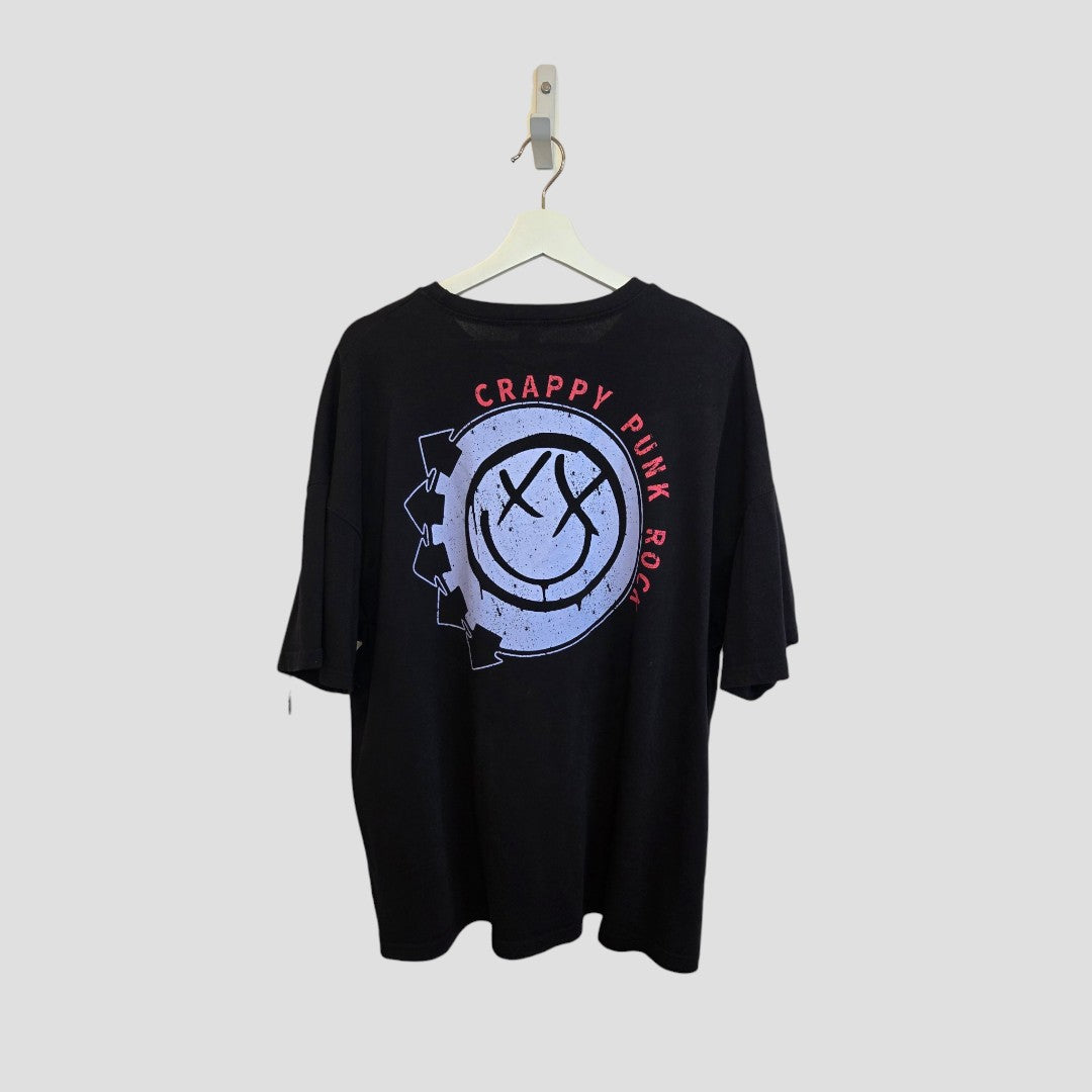 A black, eco-friendly Upcycled Breastfeeding & Pumping Blink 182 Oversized Band T-shirt (UK12) by boohoo hangs on a white hanger, featuring a large distressed smiley face and "CRAPPY PUNK ROCK" in red and white on the back.