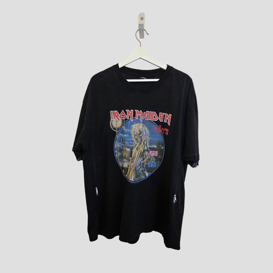 The Primark Upcycled Breastfeeding & Pumping Black Iron Maiden Killers Band T-shirt (L) hangs on a white hanger against a gray background, featuring colorful art and the band's name in red on the chest.