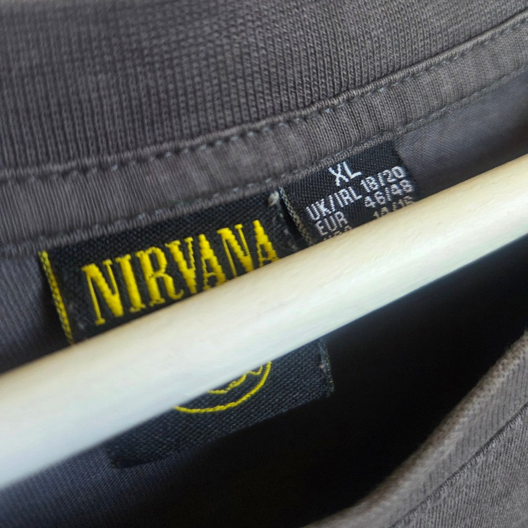 Close-up of a grey Primark Upcycled Breastfeeding & Pumping Nirvana Yellow Smile Band T-shirt (XL, UK18/20), featuring a Nirvana tag—crafted from eco-friendly materials for conscious style.