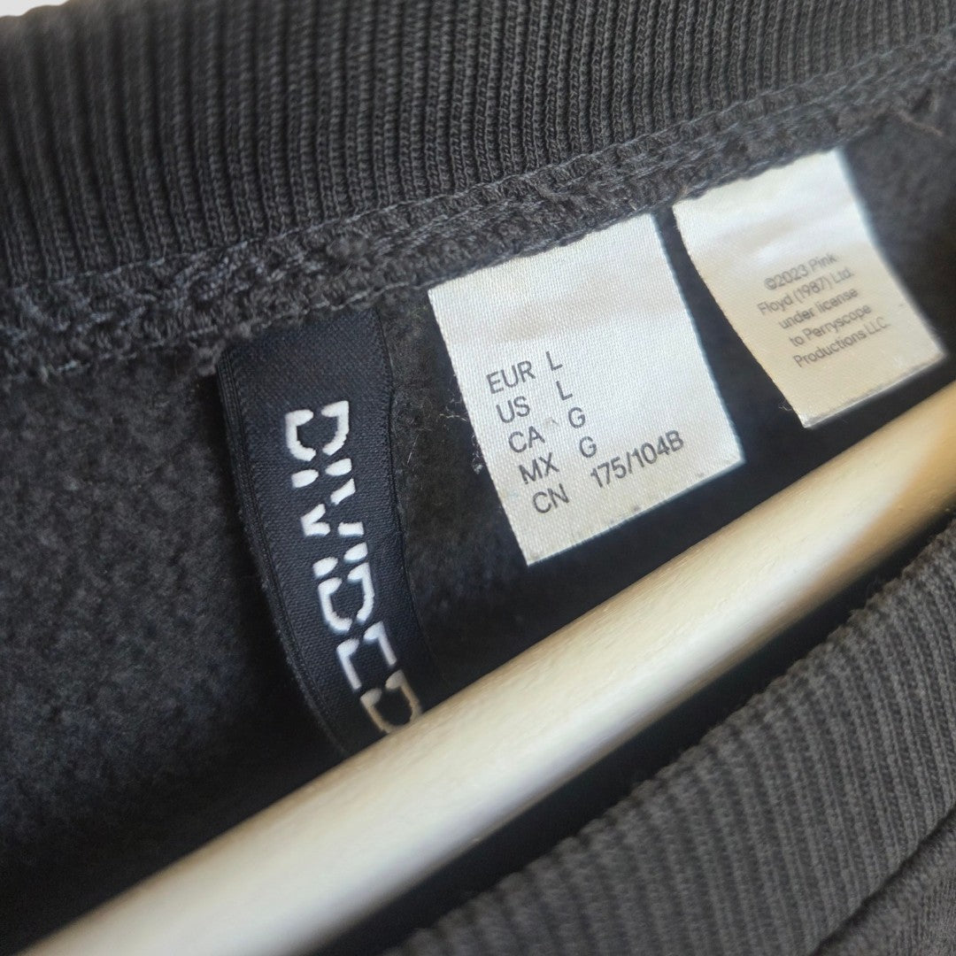 Close-up of a black label inside an affordable H&M Upcycled Breastfeeding & Pumping Grey Pink Floyd Band Sweatshirt, showing size info (EUR L, US L, CA G, MX G, CN 175/104B) and brand name in white text.