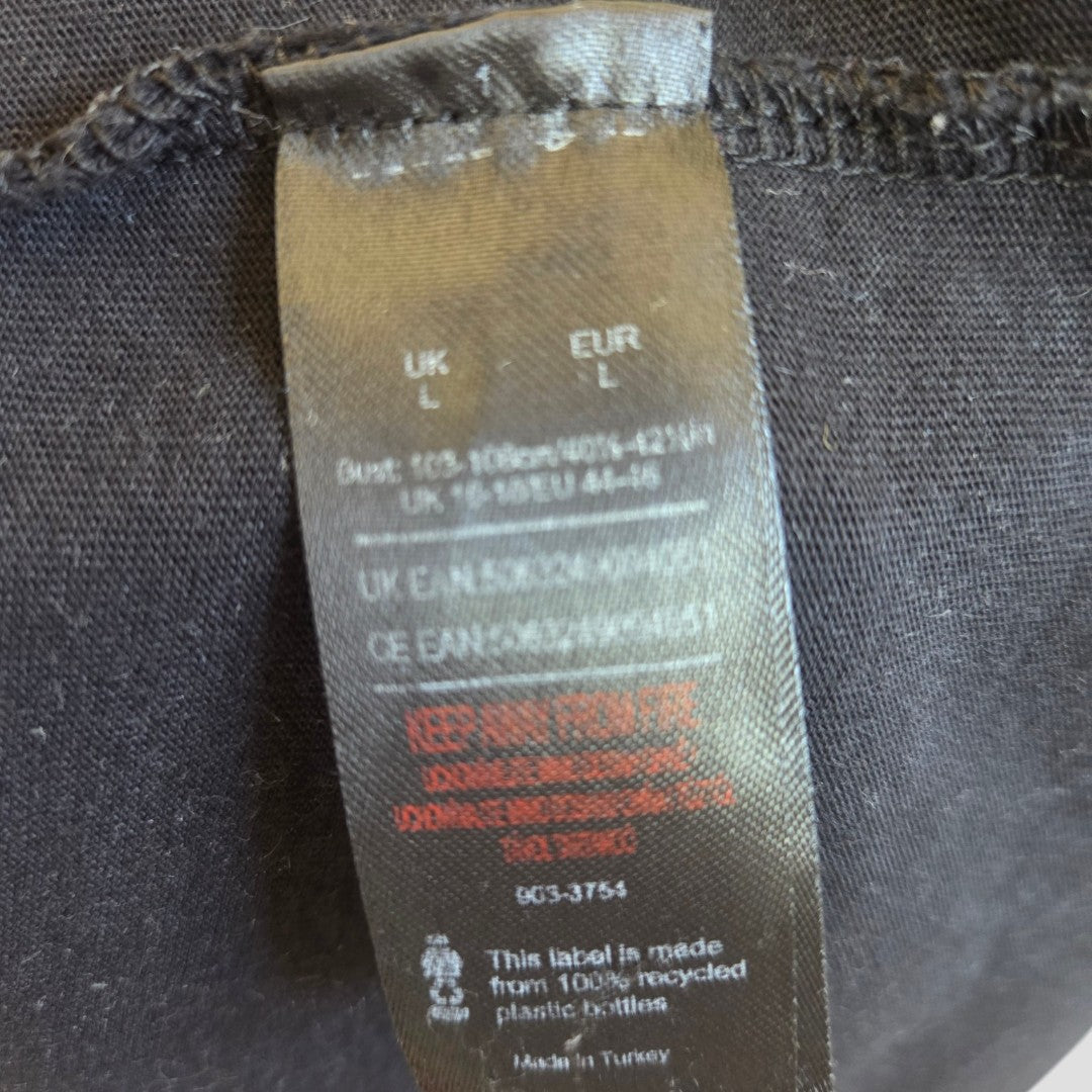 A close-up of the black tag on the Upcycled Breastfeeding & Pumping Black Snow Def Leppard Band t-shirt (L) shows size info, care instructions, and notes it's made from 100% recycled plastic bottles—eco-friendly nursing wear by Def Leppard.