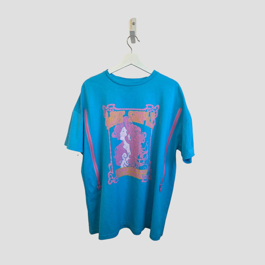 The Primark Upcycled Breastfeeding & Pumping Turquoise/Pink Girl Bow t-shirt (M, UK12/14) features pink side zippers, a large graphic of a stylized woman with flowing hair and back text, shown on a white hanger against a light background.