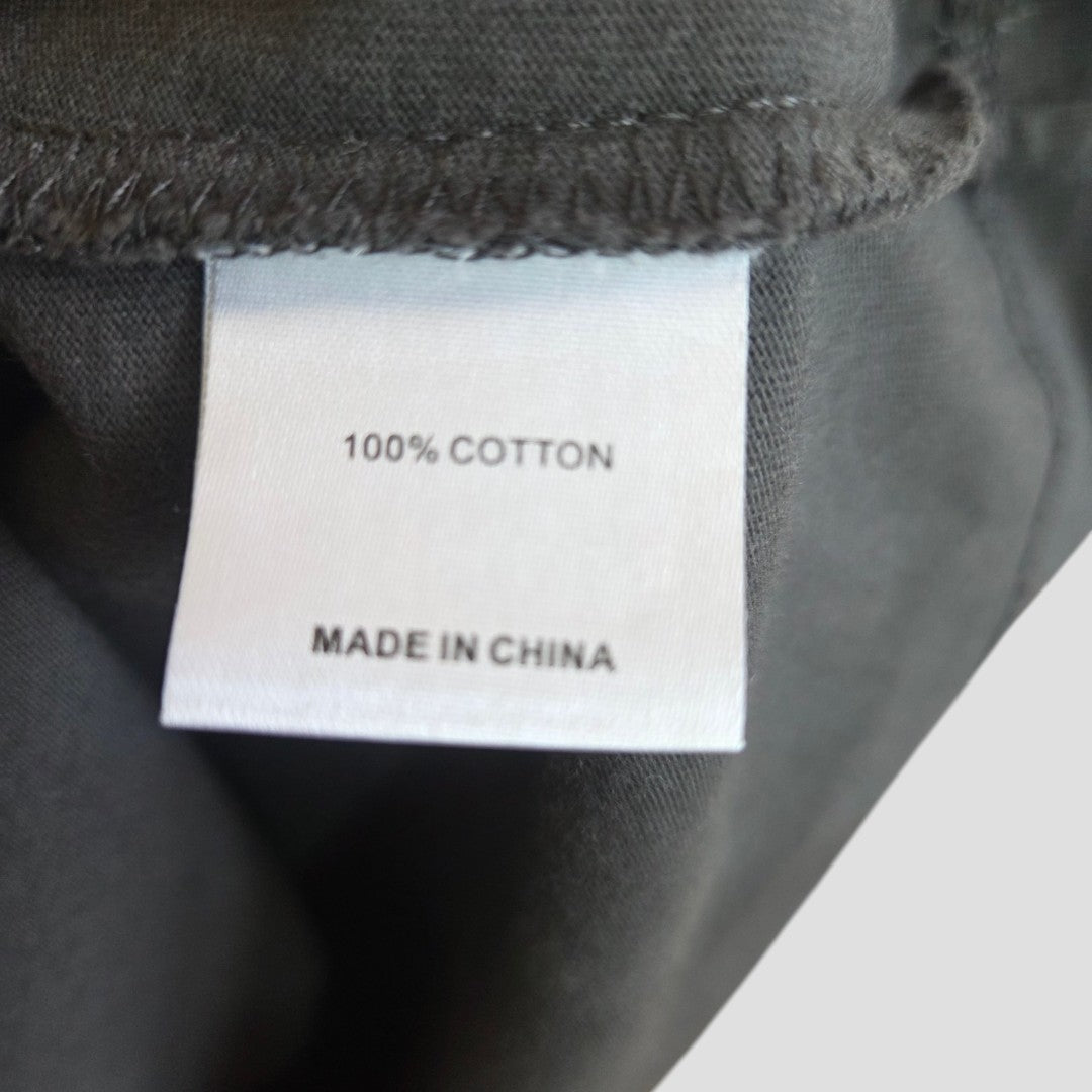 A white clothing tag on black fabric reads 100% COTTON and MADE IN CHINA, reflecting the comfort and quality of the White Fox Upcycled Breastfeeding & Pumping Grey/Red t-shirt S/M (100495).