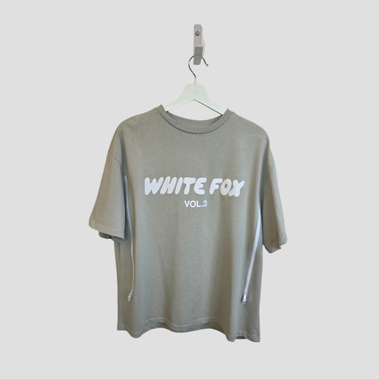 The White Fox Upcycled Breastfeeding & Pumping Khaki/White White Fox t-shirt (L) features bold "WHITE FOX VOL.3" text and white side zippers—ideal, affordable nursing wear for stylish and practical breastfeeding.