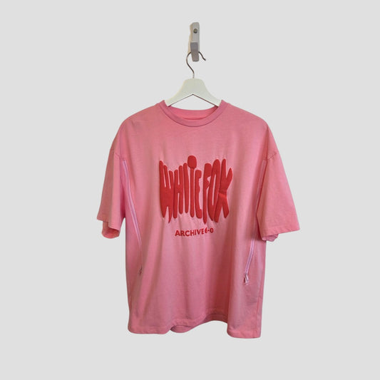 The White Fox Upcycled Breastfeeding & Pumping Pink/Red t-shirt (L, 100497) features bold graffiti-style text and eco-friendly materials, shown on a white hanger against a light background.