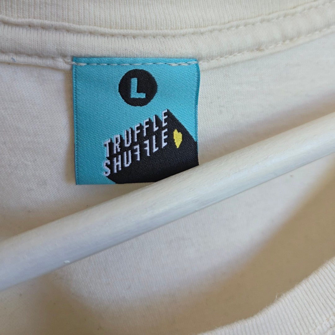 A close-up of a blue label on the white Upcycled Breastfeeding & Pumping Rainbow Kids TV t-shirt (L) by Truffle Shuffle, with the letter L and brand name in white—a stylish detail for affordable nursing wear.