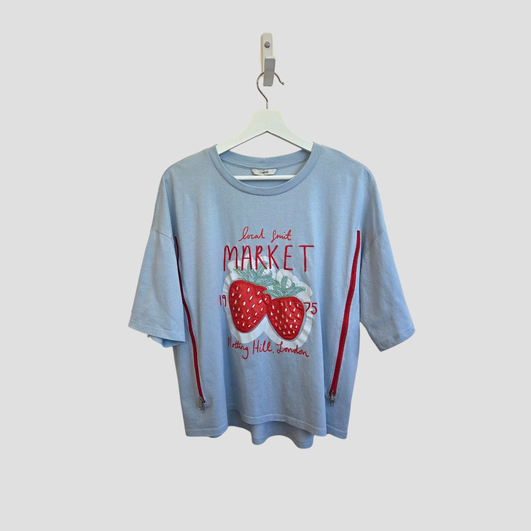 George Upcycled Breastfeeding & Pumping Blue Strawberry Market T-shirt UK16 features a light blue short sleeve with red side zippers, a large red strawberry, and “Land Fruit Market 1975, Notting Hill, London” text. Eco-friendly nursing top on white hanger.