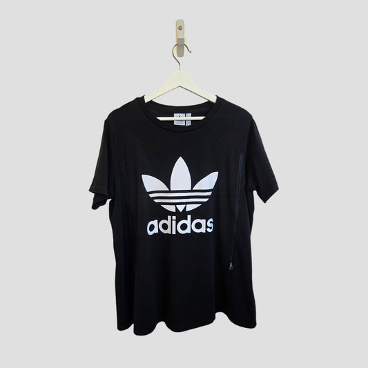 Upcycled Adidas XXL black/white logo T-shirt (UK24/26) for breastfeeding & pumping, hanging on a wooden hanger against a plain light gray background. Comfortable option for casual nursing wear.