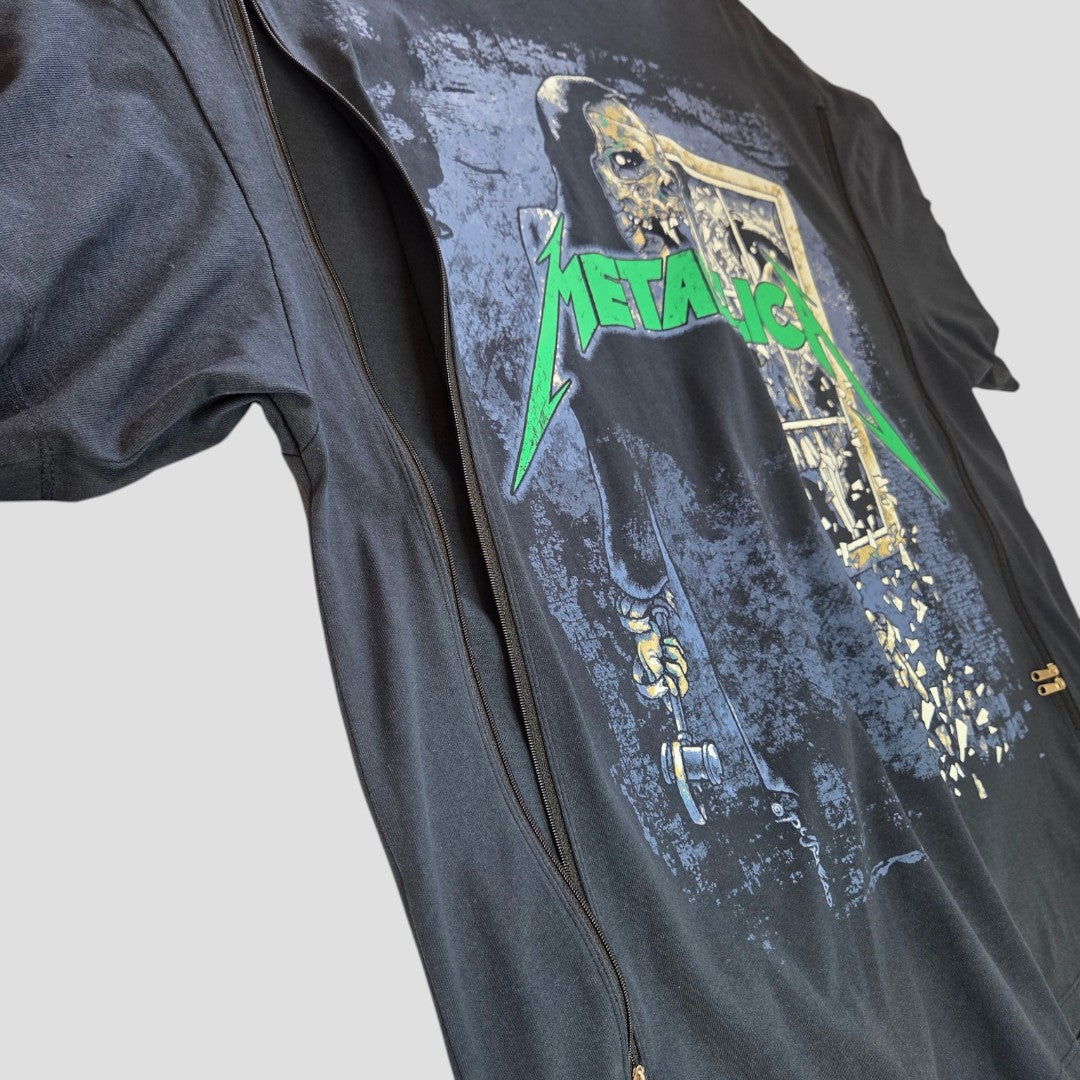 Close-up of an H&M Upcycled Breastfeeding & Pumping Navy/Green Metallica Band t-shirt XL, featuring a skeleton with a key at a door and the green Metallica logo. Eco-friendly shirt is partially unzipped and laid on a light surface.