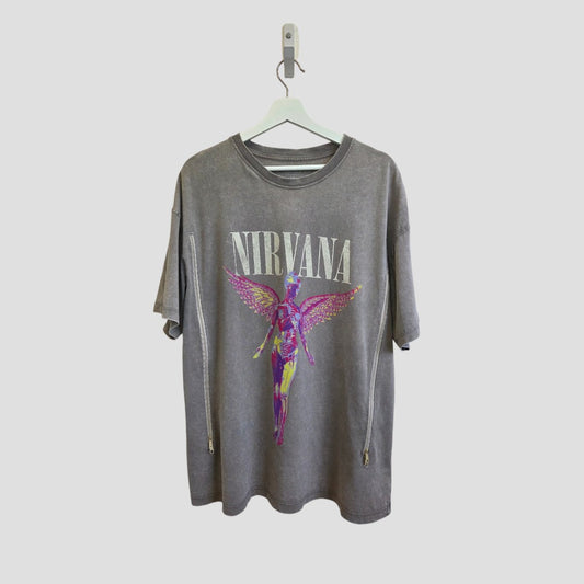 A Primark Upcycled Breastfeeding & Pumping Nirvana Angel Band T-shirt (grey/pink, M UK12/14) hangs on a hanger, featuring "NIRVANA" in bold white letters above a colorful winged anatomical figure.
