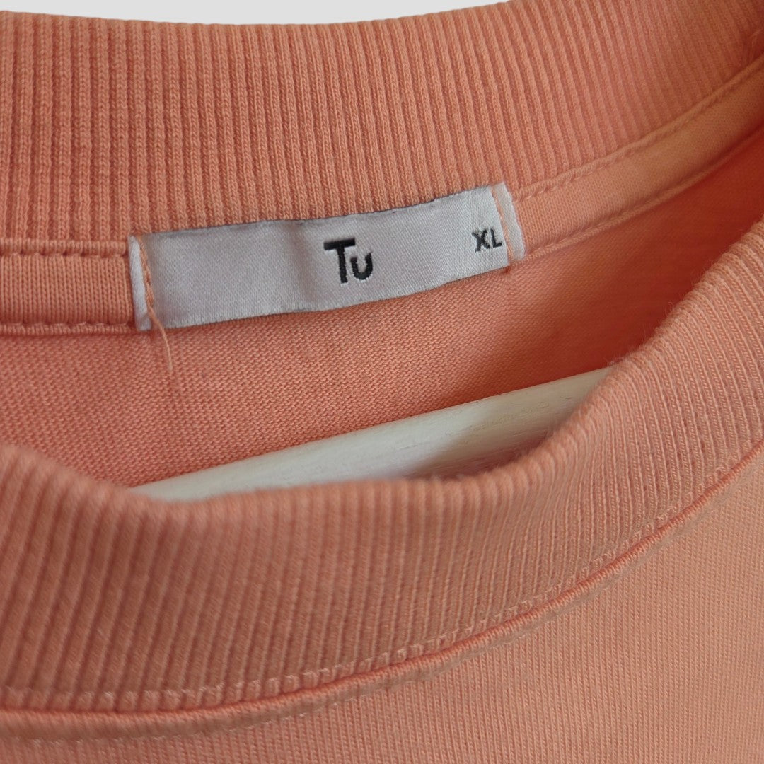 Close-up of the Upcycled Breastfeeding (Nursing) & Pumping Coral Paradiso Italiano t-shirt XL by Tu, highlighting the neckline with a white label marked with the brand name and size—eco-friendly and affordable nursing wear.