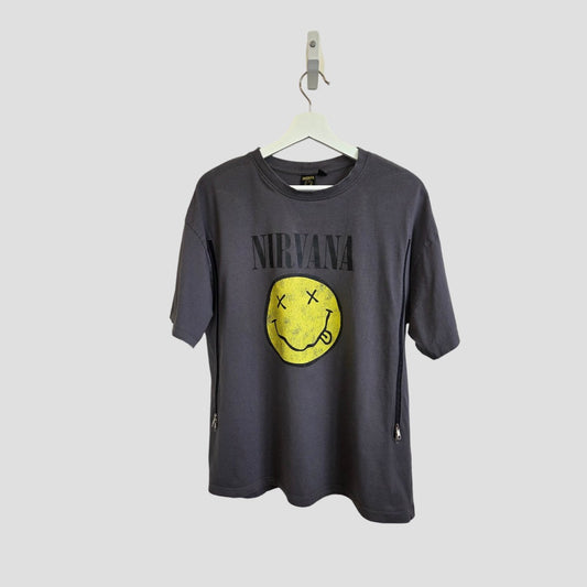 The Primark Upcycled Breastfeeding & Pumping Grey Nirvana Yellow Smile Band T-shirt (S, UK10/12) features the band’s name above a yellow smiley face. Perfect for casual style, comfort, and nursing or pumping on the go.