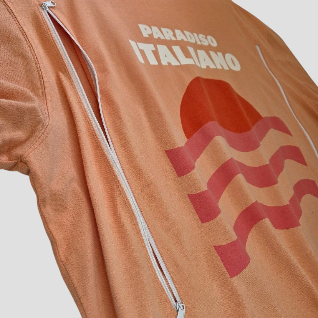 The Tu Upcycled Breastfeeding & Pumping Coral Paradiso Italiano t-shirt XL (100546) features white zippers for easy nursing, a red wave and sun graphic with "PARADISO ITALIANO," and is a stylish, eco-friendly choice for on-the-go moms.