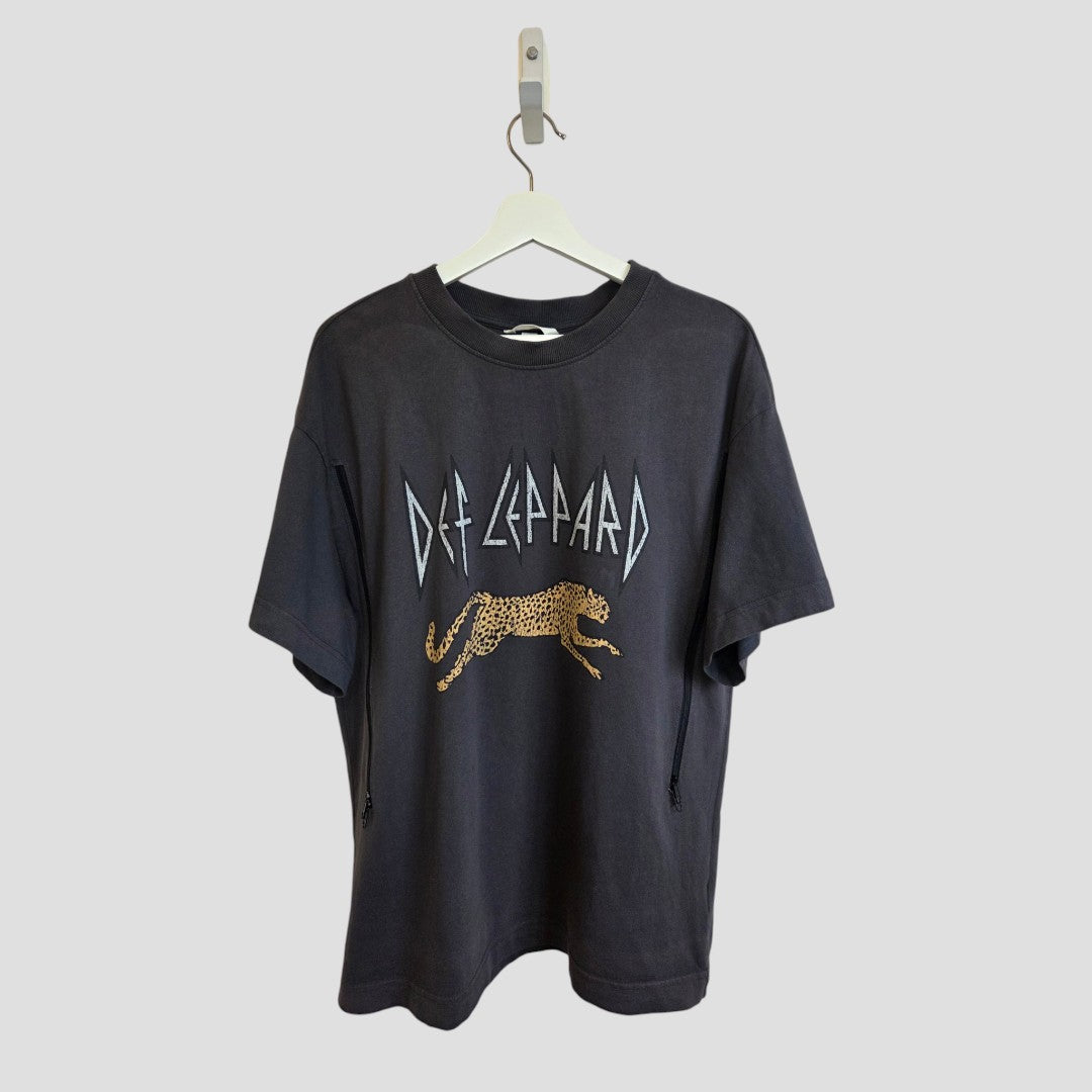 An upcycled H&M Grey Def Leppard Band nursing & pumping t-shirt (L, 100579) hangs on a white hanger against a plain grey background, featuring the band name and leaping leopard graphic in white.