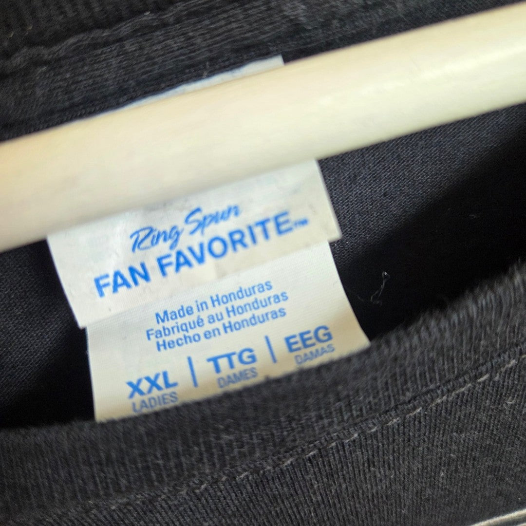 A close-up of a tag inside a black upcycled Port & Company KISS Band nursing t-shirt (XXL), showing sizes for ladies (TTG, EEG) and made in Honduras—an affordable breastfeeding and pumping wear option.