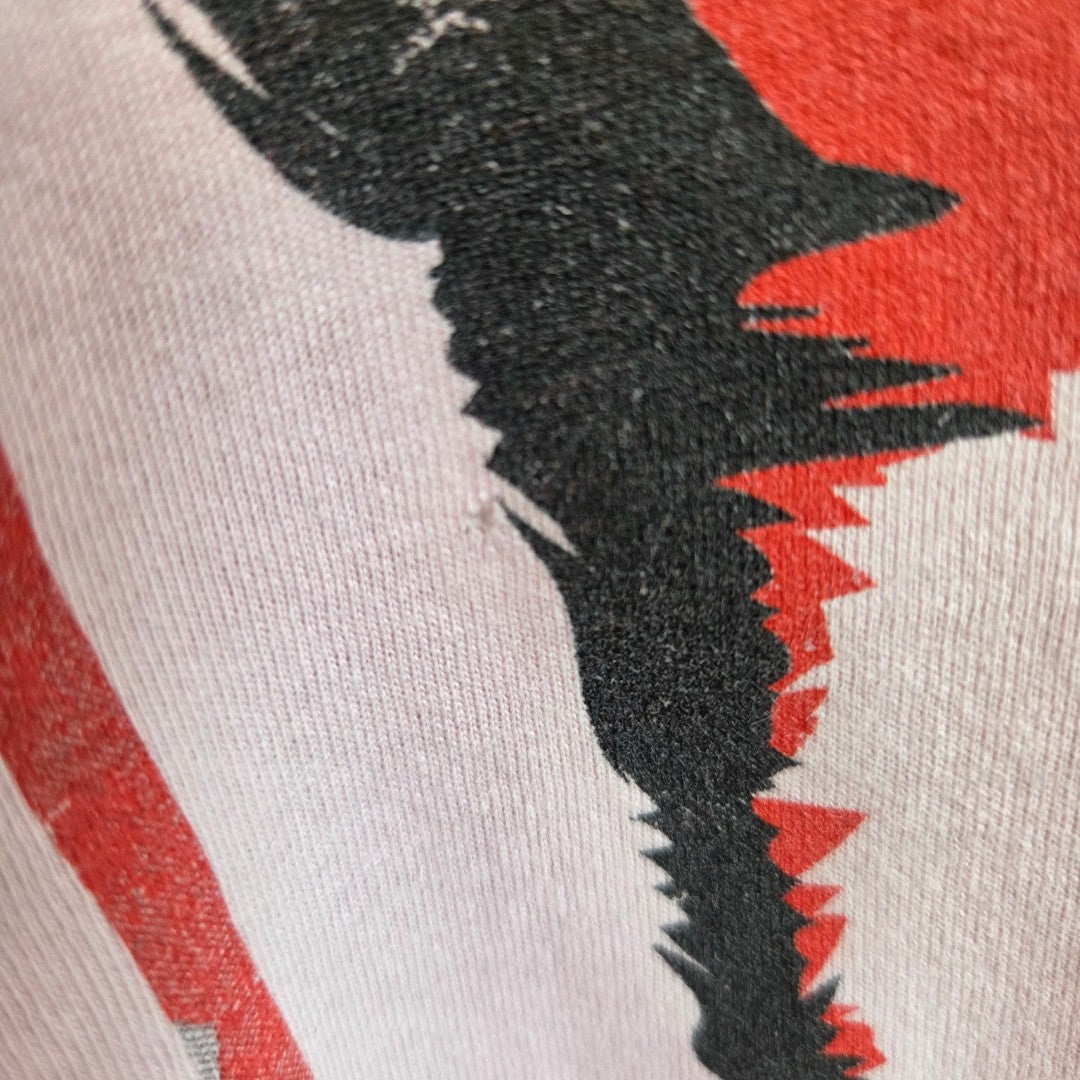 Close-up of fabric from Amplified's affordable Upcycled Breastfeeding & Pumping Pink David Bowie Band t-shirt (L), showing a black and red jagged, abstract print on white with a slightly distressed look.