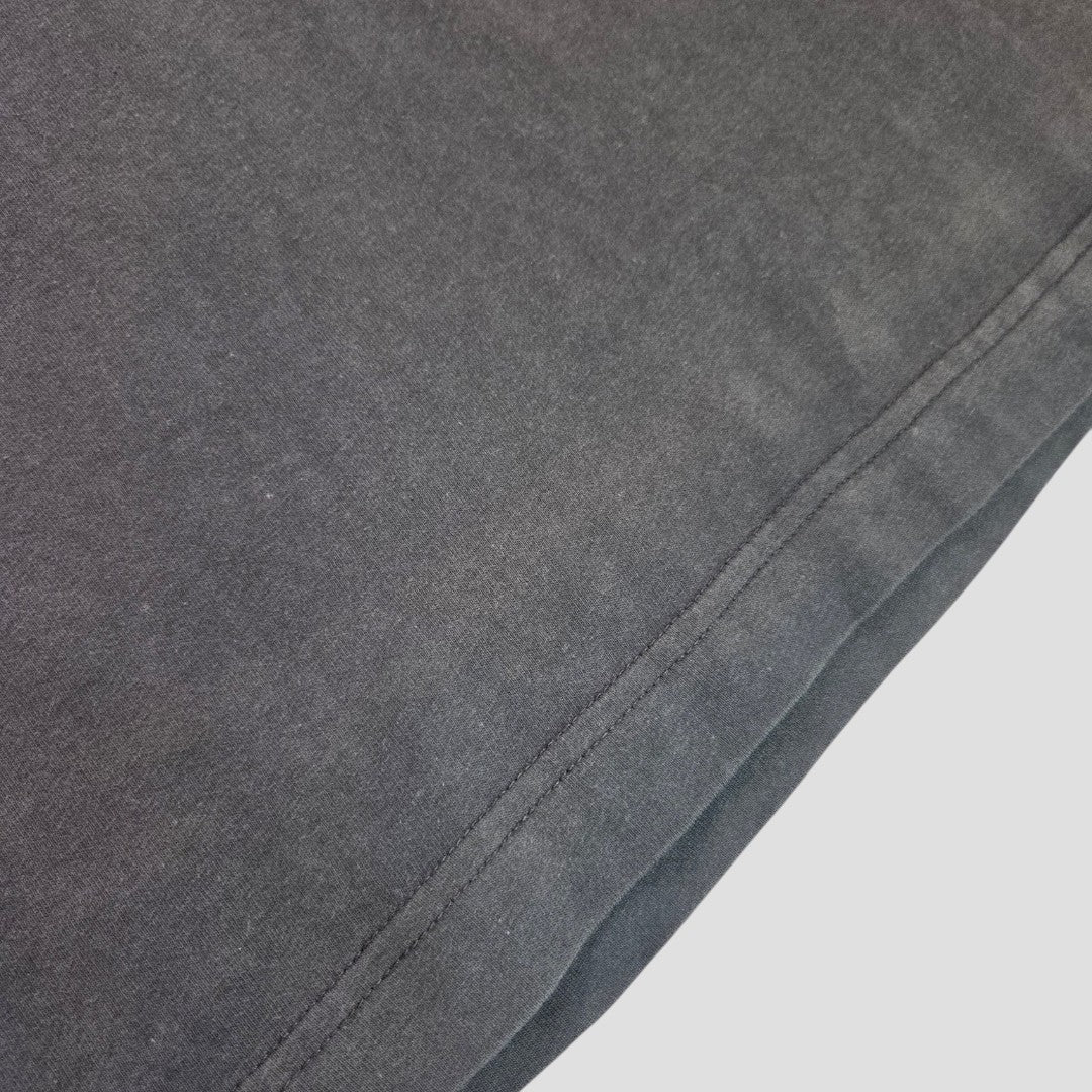 Close-up of the hem and stitching details on an upcycled H&M Grey Def Leppard Band T-shirt (size L, 100579), designed for breastfeeding and pumping, with visible fabric texture against a light background.