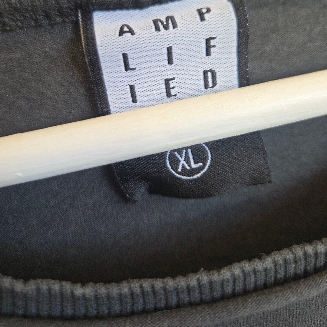 A close-up of a clothing label reading Amplified and a second smaller tag below it showing the size XL, both attached to the Upcycled Breastfeeding (Nursing) & Pumping Grey Red Hot Chilli Peppers Band t-shirt XL (100563) by Amplified, displayed on a hanger.