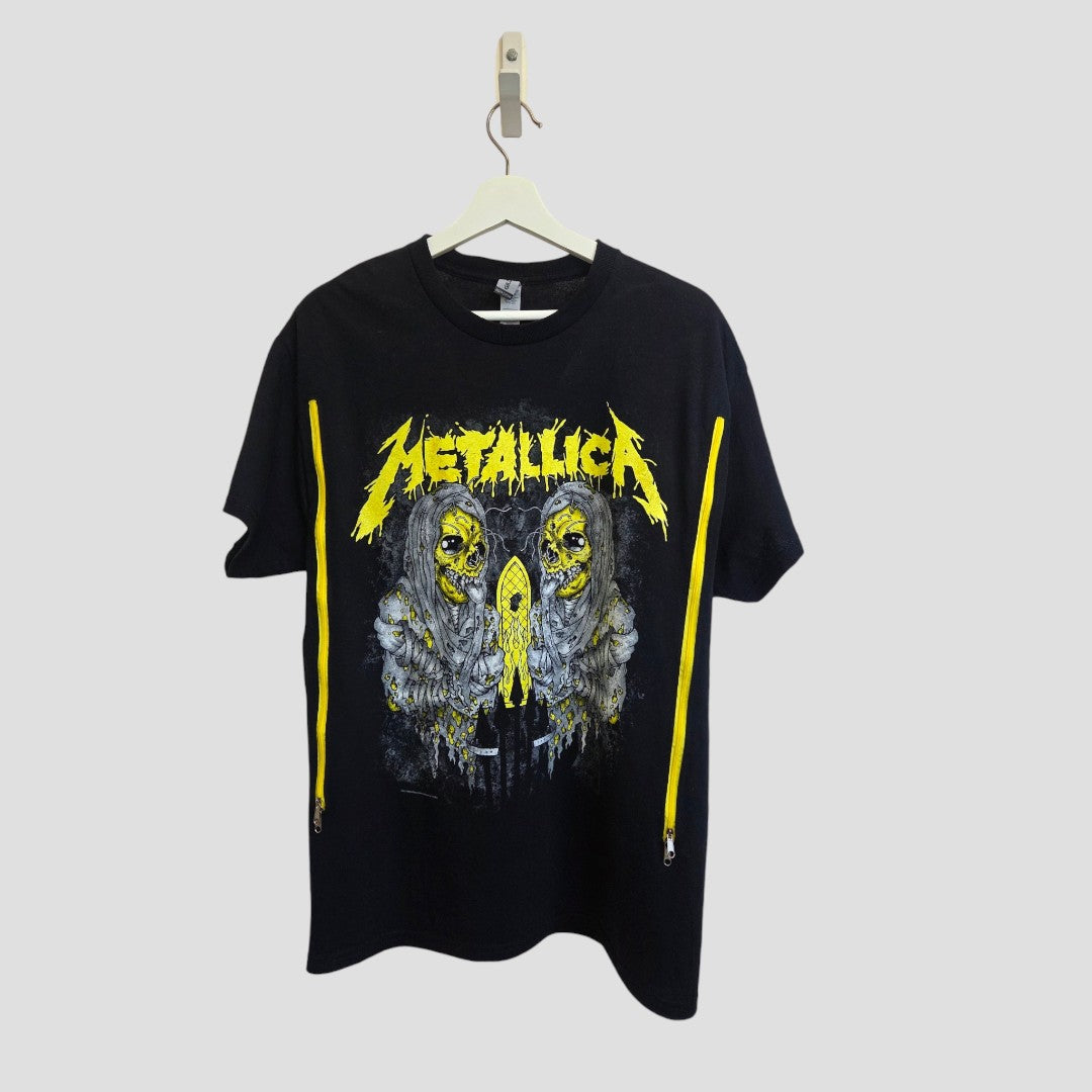 Upcycled Gildan Breastfeeding & Pumping Black/Yellow Metallica Band T-shirt (Size L) hanging on a hanger, featuring the iconic yellow band logo and two skulls with yellow accents on the chest—a bold addition to your breastfeeding wardrobe that fuses classic rock style with the comfort of an eco-friendly nursing top.