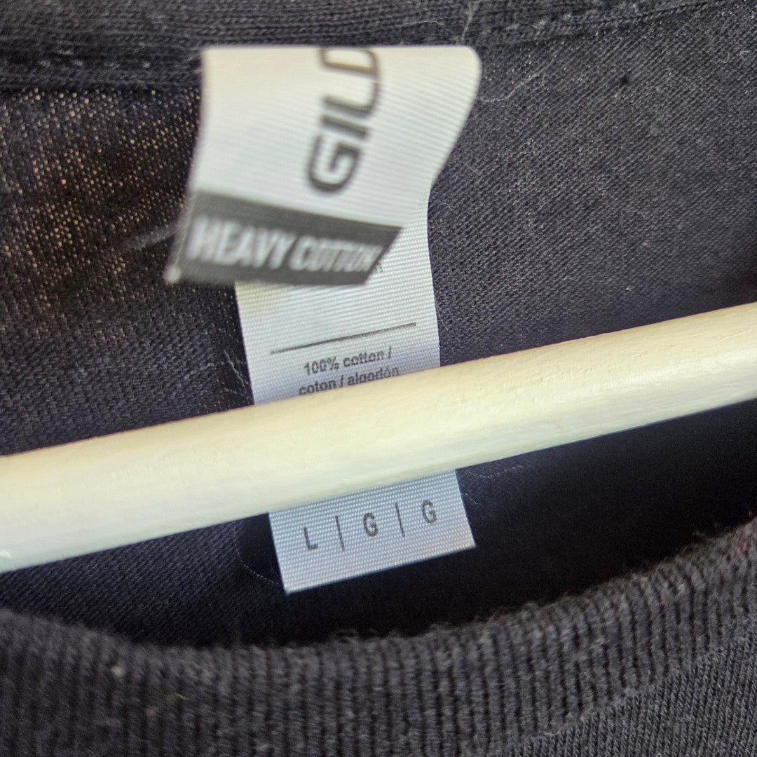 Close-up of an upcycled Gildan black/yellow Metallica Band t-shirt for breastfeeding (nursing) and pumping, size L, featuring tags that read Gildan Heavy Cotton, 100% cotton, and size label L | G | G. This comfortable piece can be effortlessly styled as casual nursing clothing or layered over an eco breastfeeding top for added versatility.