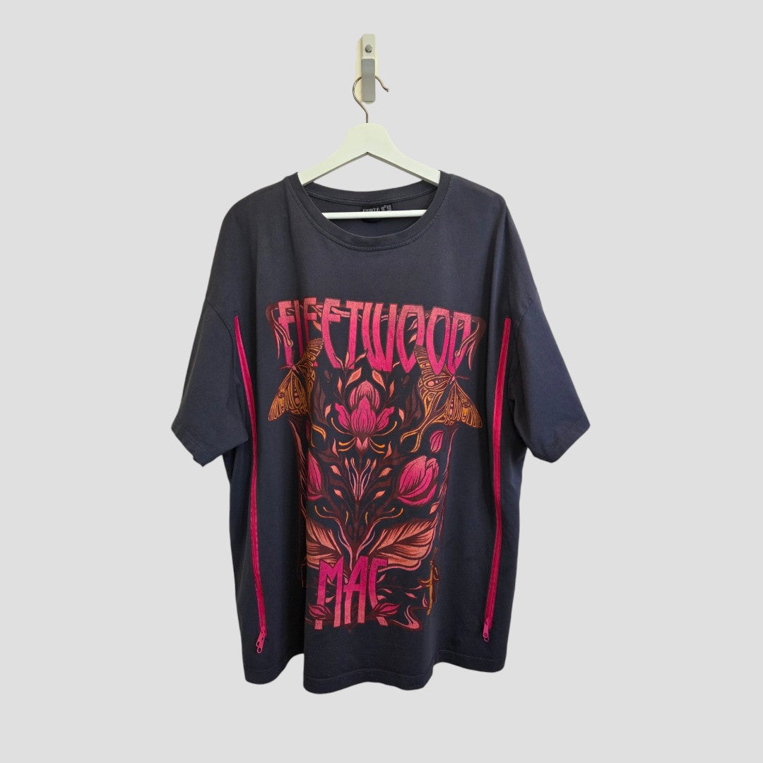 An upcycled Primark Fleetwood Mac band T-shirt in black (size XL, UK 18/20) hangs on a hanger, featuring pink and orange floral designs with moths and “FLEETWOOD” boldly printed across the front—an affordable, stylish option ideal for everyday wear, as well as convenient nursing and pumping.