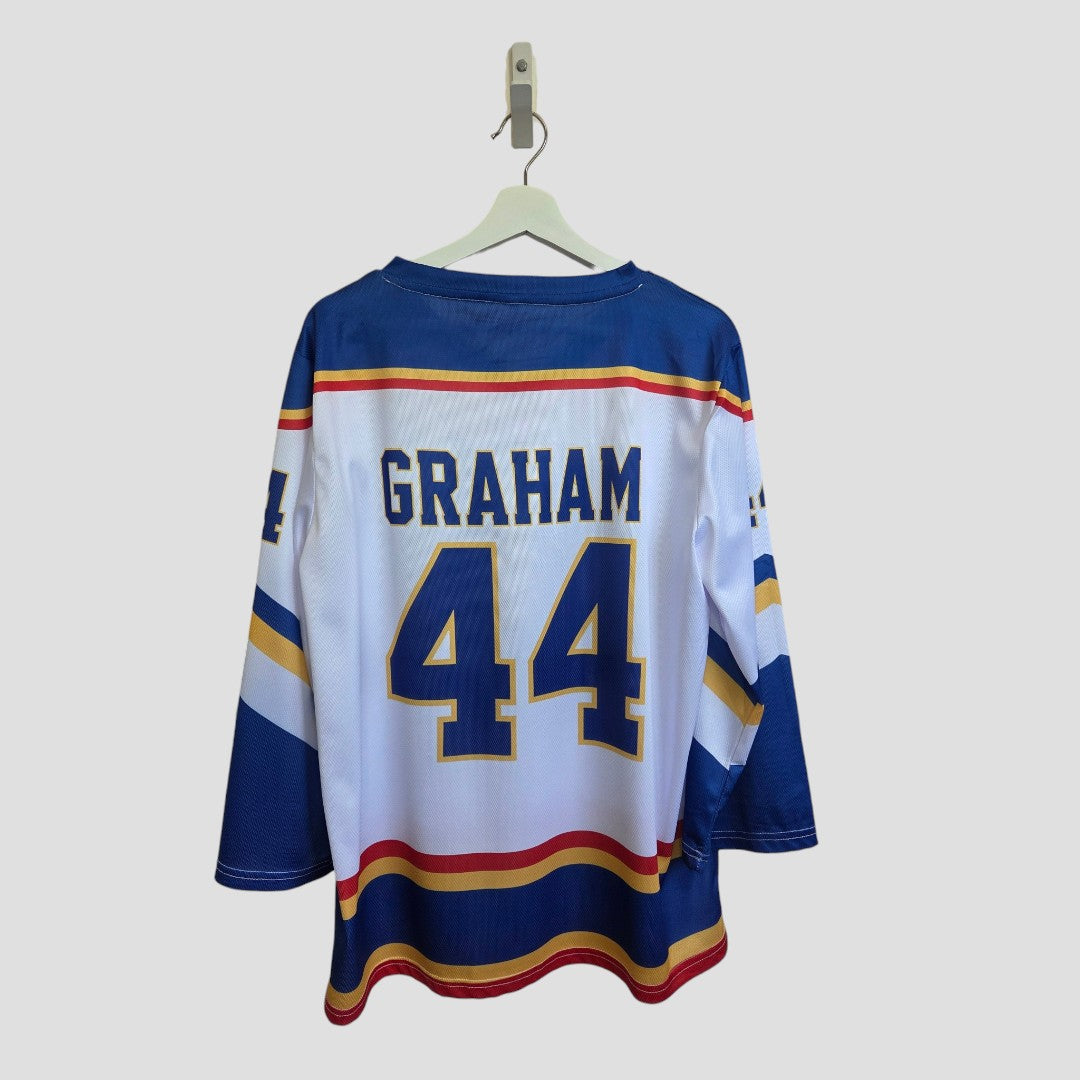 An Upcycled Breastfeeding (Nursing) & Pumping White Off Campus Ice Hockey Jersey t-shirt XL (100599) by Amazon—a blue, white, and yellow hockey jersey featuring "GRAHAM" and the number 44 on the back. It’s a stylishly versatile eco-friendly alternative for everyday nursing, shown hanging on a white hanger against a plain light gray background.