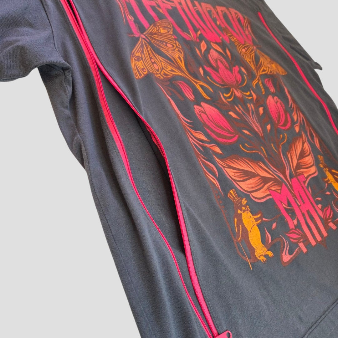 A gray Primark jacket, upcycled from a Fleetwood Mac band t-shirt (size XL, UK 18/20), features pink zippers and a vibrant, artistic back design with flowers, moths, and patterns in red, orange, and yellow hues. Designed as affordable breastfeeding and pumping clothing for nursing mothers, this piece combines style with functional access.