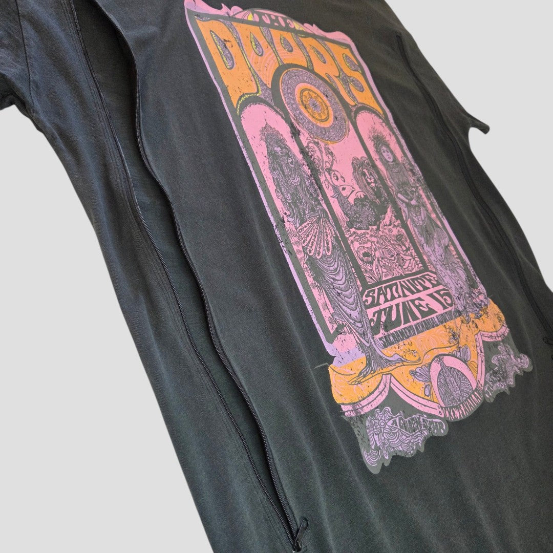 An upcycled Primark oversized band T-shirt dress (UK14/16) featuring a vintage-style, colorful The Doors concert graphic in purple and yellow, photographed from a low angle against a plain gray background. Designed as breastfeeding (nursing) and pumping wear, this relaxed-fit dress combines comfort with easy styling for everyday use.