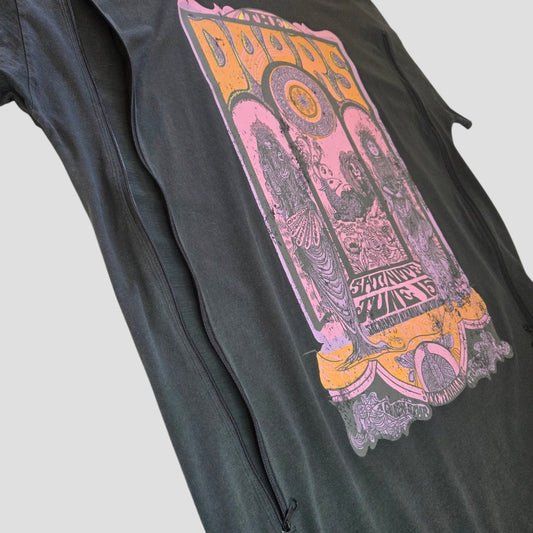 An upcycled Primark oversized band T-shirt dress (UK14/16) featuring a vintage-style, colorful The Doors concert graphic in purple and yellow, photographed from a low angle against a plain gray background. Designed as breastfeeding (nursing) and pumping wear, this relaxed-fit dress combines comfort with easy styling for everyday use.