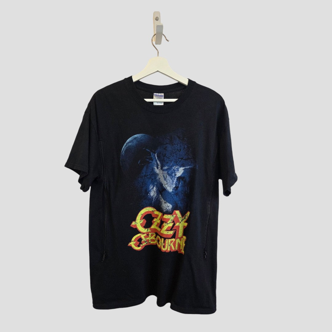 A black Gildan Upcycled Breastfeeding (Nursing) & Pumping Ozzy Osbourne Band t-shirt in size L (100612) hangs on a hanger, featuring a bat with outstretched wings silhouetted against a blue moon and “Ozzy Osbourne” written in bold yellow and red text below—an affordable and stylish nursing wear choice for rock-loving moms who value comfort.