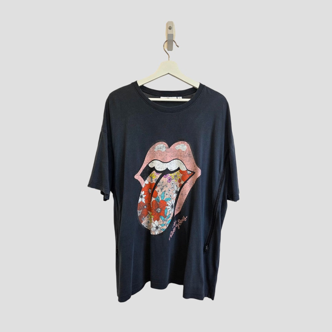 Next Upcycled Breastfeeding (Nursing) & Pumping Grey Floral The Rolling Stones Band t-shirt XL (100608) displayed on a hanger, features the iconic pink lips and tongue graphic accented with a vibrant floral design, set against a plain light background. This eco-friendly and affordable tee blends playful style with mindful choices—ideal for those who prioritize comfort and sustainability.